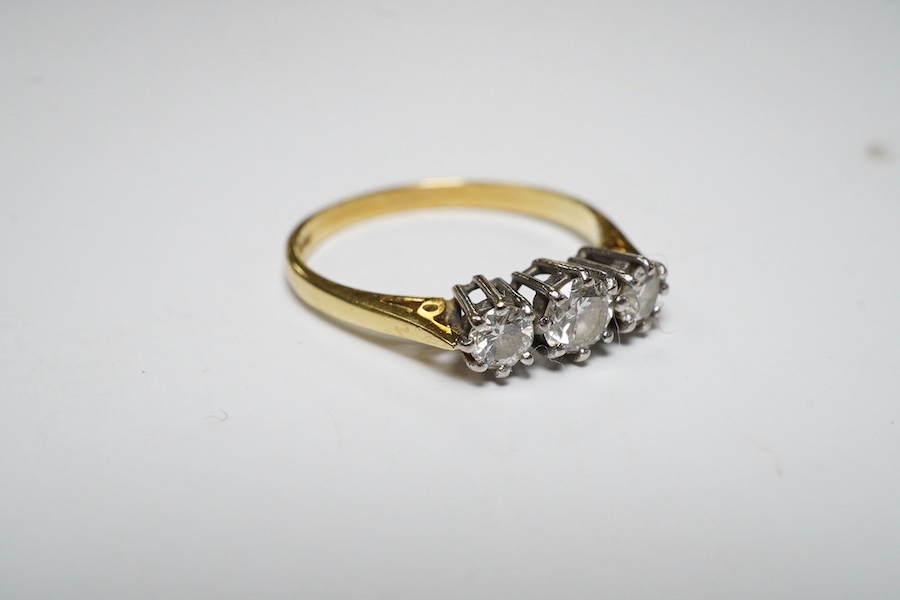 A modern 18ct gold and three stone diamond set ring, size M, gross weight 2.1 grams. Condition - fair to good